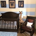 View of striped wall and crib in nursery