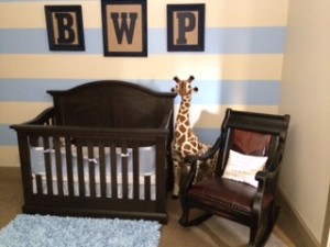 View of striped wall and crib in nursery